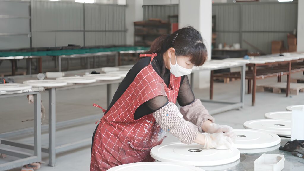 Processus de finition et contrôle qualité des plaques de poids (bumper plates) blanches dans l'usine OMIGYM.
